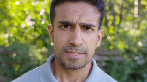 Close Up - Handsome man looks into the camera upset and bothered. - Slow Motion Stock Footage 125160506