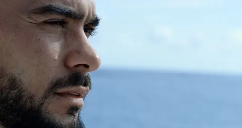Close-up of of a handsome man from the side with a beard and long brown hair. We Vídeos de archivo 154693457