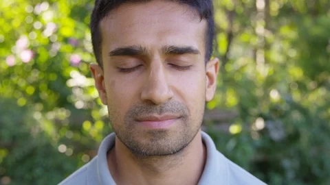Close Up - Handsome man takes a deep breath with his eyes closed outside - Slow Stock Footage 125160159