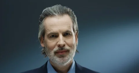 Close up of handsome senior gray-haired businessman looking at camera and Stock Footage 125466616