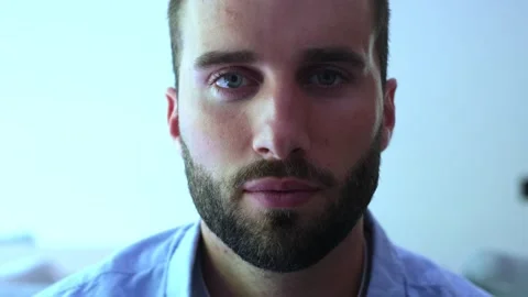 Close-up of a handsome young bearded man opening his beautiful blue eyes Stock Footage 345123732