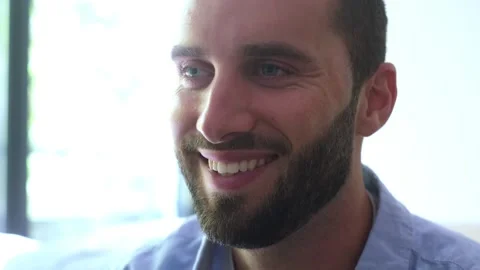 Close-up of a handsome young caucasian man with a beard and blue eyes Vídeos de archivo 344782356