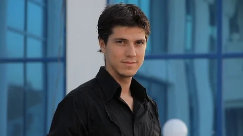 Close up of handsome young man against modern business building Video stock 73827760