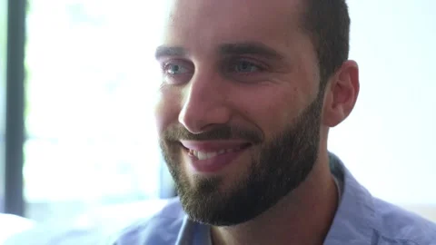 Close-up of a handsome young man with a beard and blue eyes opening his eyes Vídeos de archivo 344782418
