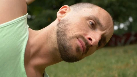 Close-up of handsome young mans face during exercise in park Stock Footage 114874378
