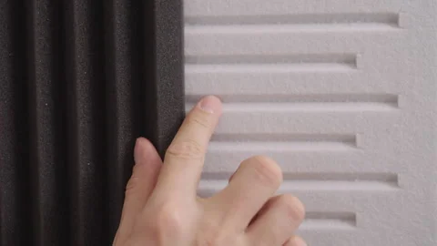 Close-up of handyman choosing between two types of soundproof wall panels Stock Footage 324866760