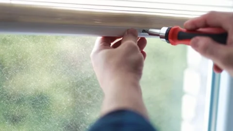 Close up of a handyman hand adjusting a white window sunshade with a tool Vídeos de archivo 340159512