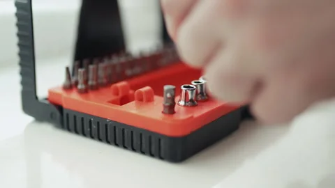 Close-up of a handyman in a jumpsuit assembling a multi-bit screwdriver, profess 스톡 동영상 335643707