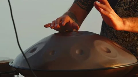Close up of a hang drum, a man is playing meditation music outdoors, 4k Stock Footage 143246421