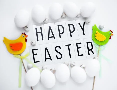 Close up of happy Easter greetings, eggs and decorative chicks over white Stock Photos