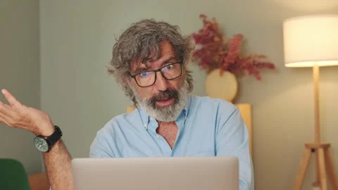 Close up, happy elderly man in glasses in living-room talking online via video Stock Footage 255963033
