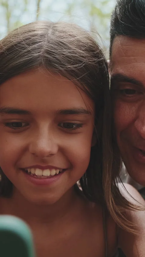 Close up, happy family using smart phone looking at pictures and videos sitting Stock Footage 256765755