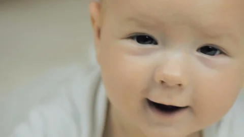 Close-up of a happy  five-month-old baby looking at the camera and smiling in... Stock Footage 99076244
