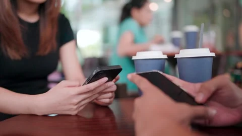 Close-up of happy friends having fun with their devices together watching funny  Stock Footage 265766864