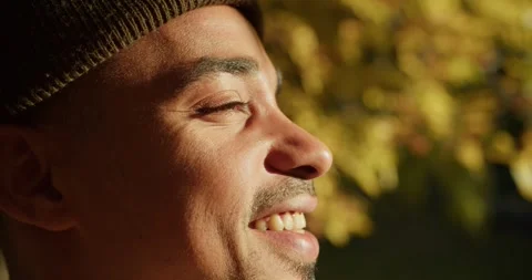 Close up Happy guy face with Black skin and brown eyes smiles and looks at the Stock Footage 299924693
