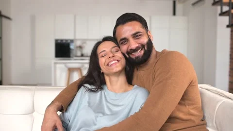 Close-up of happy interracial couple posing while sitting at the sofa with Video stock 166839531