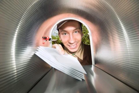 Close-up Of Happy Mailman Placing Envelopes View From Inside The Mailbox Stock Photos
