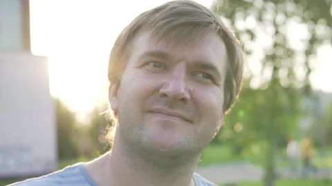 A close-up of a happy man at sunset while walking in the park in the summer. Stock Footage 132342169
