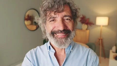 Close-up of happy middle-aged man, with gray hair, standing in the living room Stock Footage 252502418