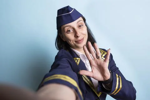Close up of happy stewardess using smartphone frontal camera to do selfie Stock Photos