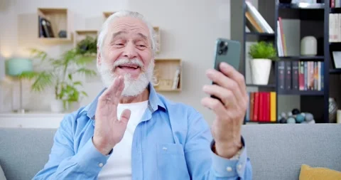 Close-up happy upbeat old man making video call sitting on sofa. Easy-going Stock Footage 220302768