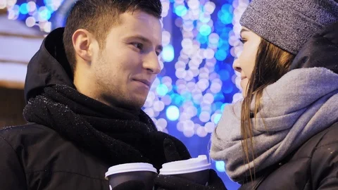 Close-up of Happy young couple drinking coffee on the Xmas fair. Beautiful Stock Footage 100618489