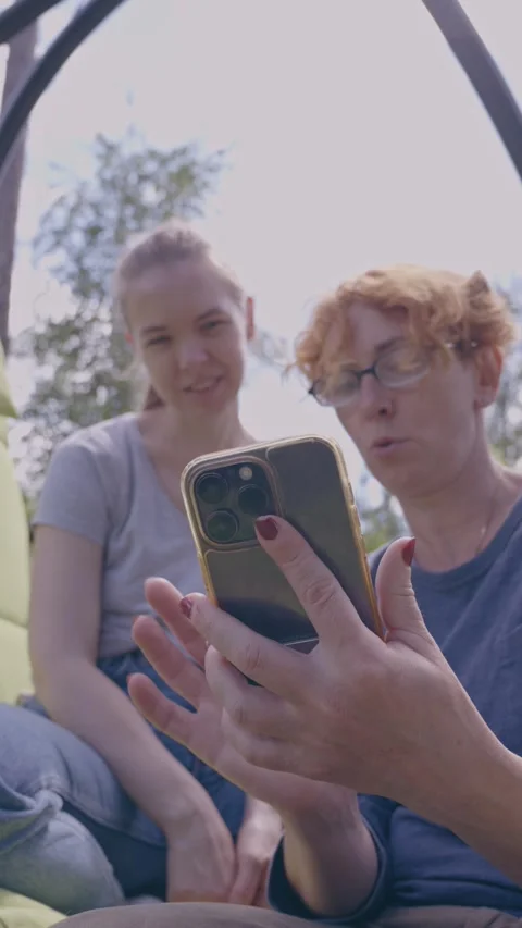Close-up of a happy young couple sharing a smartphone screen outdoors Stock Footage 318963798