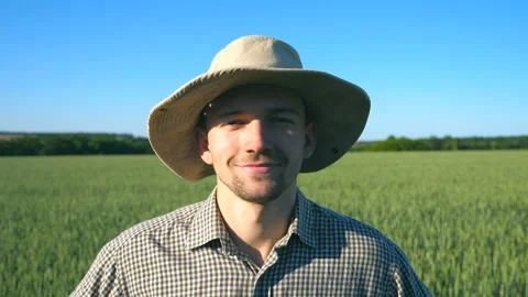 Close up of happy young farmer in hat looking and smiling into camera Stock Footage 100632107