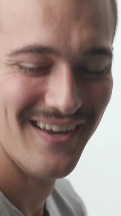 Close-up of Happy Young Man Turning and Laughing at Camera on White Backgroun Stock Footage 341659465