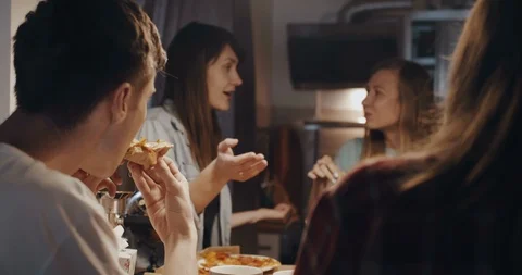 Close-up happy young multiethnic student friends having pizza and talking at Stock Footage 116319963