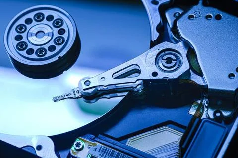  Close-up of hard disk drive internals bathed in blue light, showcasing re... Stock Photos