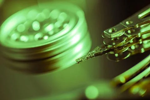  Close-up of a hard disk drive reading data, bathed in a vibrant green lig... Stock-Fotos