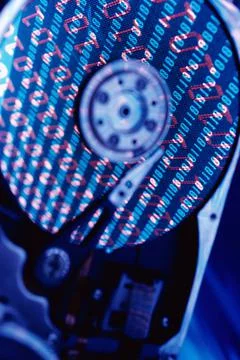 Close up of a hard drive with binary code superimposed over it 스톡 사진