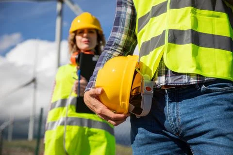 Close-up of a hardhat held by an engineer with his female colleague in the .. Foto stock