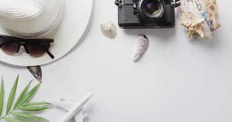 Close up of hat, sunglasses, camera, seashells and plane model on white Stock Photos