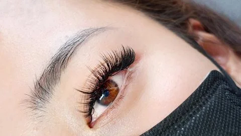 Close up of hazel eye with eyelash Extensions in beauty salon Stock Photos