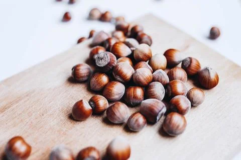 Close up of hazelnuts on board. White background Stock Photos