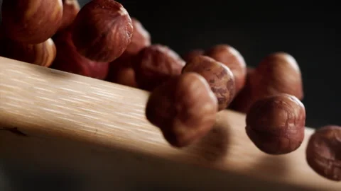 Close up of hazelnuts falling from a cutting table Stock Footage 152384064