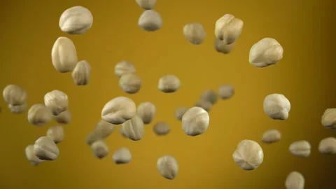 Close up of hazelnuts flying up and rotating on the yellow background Video stock 230230120