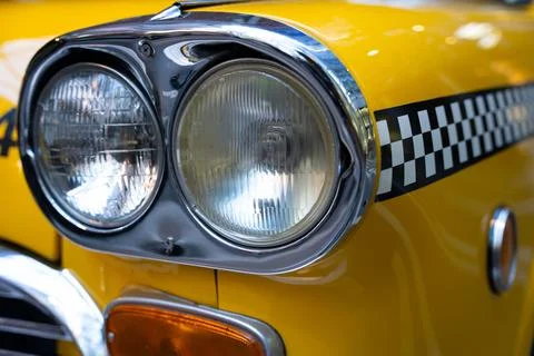 Close up of a head light of an old yellow taxi can with checkered pattern Stock Photos