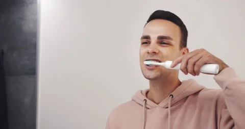 Close up head shot mirror reflection young happy man brushing teeth with Stock Footage 138905446