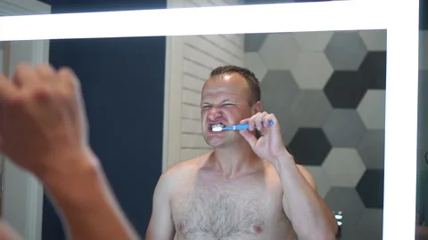 Close up head shot mirror reflection young man brushing teeth with toothpaste Stock Footage 159502271