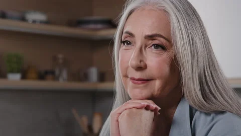 Close up head shot portrait smiling senior woman relaxing at home put chin on Stock Footage 214501601