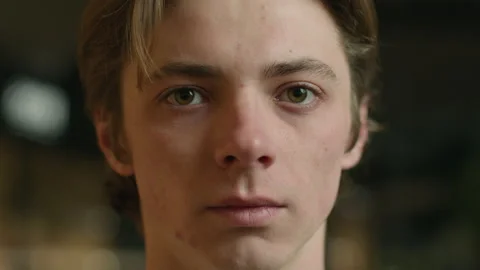 Close-up head shot sad man face Caucasian European guy student looking serious Video stock 235611638