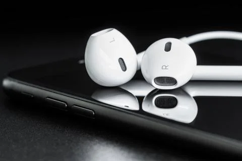 Close-up headphone stack on phone, modern phone's earbuds device accessories Stock Photos
