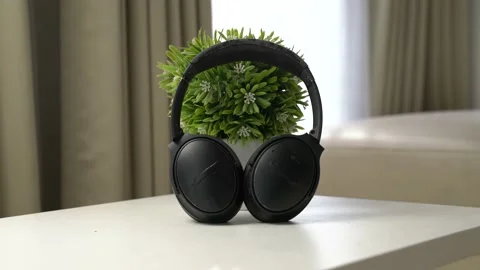 Close up headphone on the white table with flower vase behind Video stock 163863141