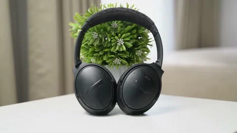 Close up headphone on the white table with flower vase behind Video stock 163863175