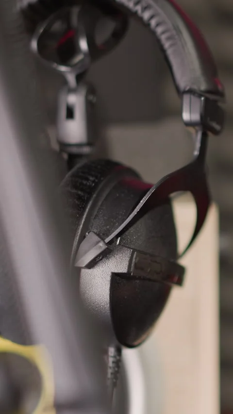 Close-Up of Headphones Hanging on Mic Stand in Blurred Recording Studio Stock Footage 309710429