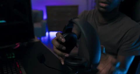 Close-up on a headset which is taken by man playing computer games on Stock Footage 177895565