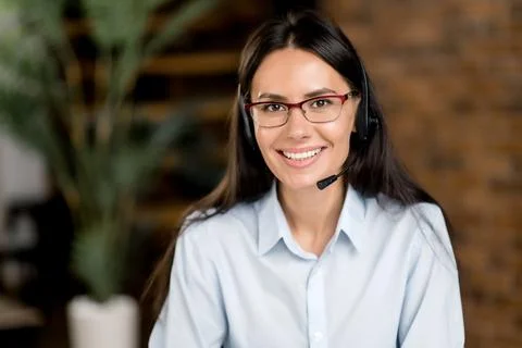 Close-up headshot of happy young brunette caucasian woman wearing headphones and Stock Photos